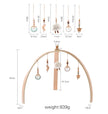 Wooden baby mobile with hanging elements and measurements on a white background
