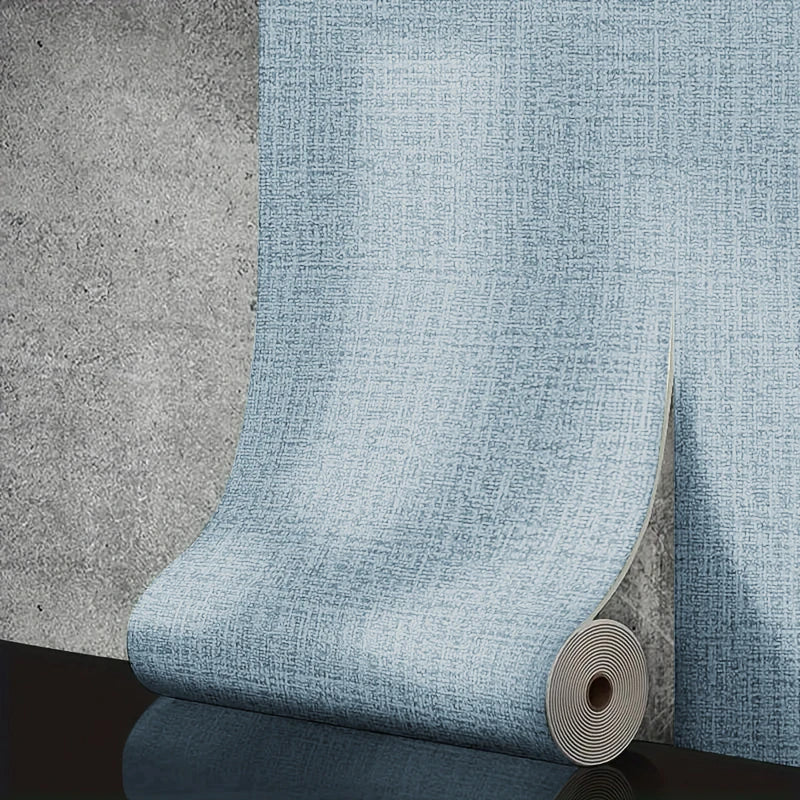 Roll of blue textured wallpaper on a concrete surface