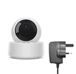 Smart home security camera with power adapter on a white background