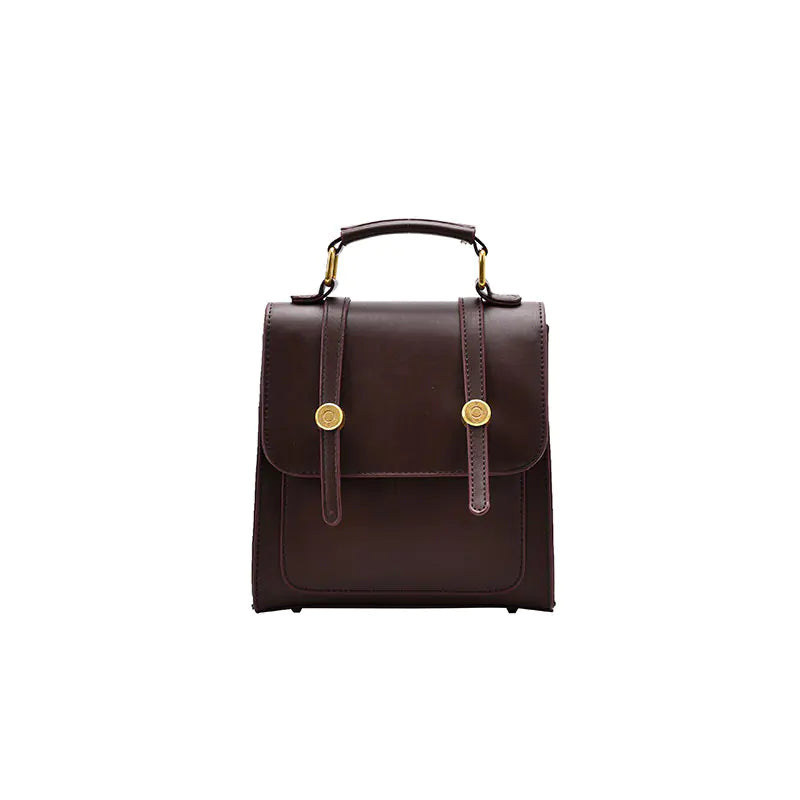 Brown leather backpack with gold accents on a white background