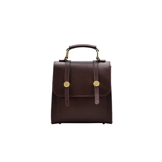 Brown leather backpack with gold accents on a white background