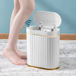 White electronic device with a wireless charging pad on a textured surface, with a person's leg in the background.