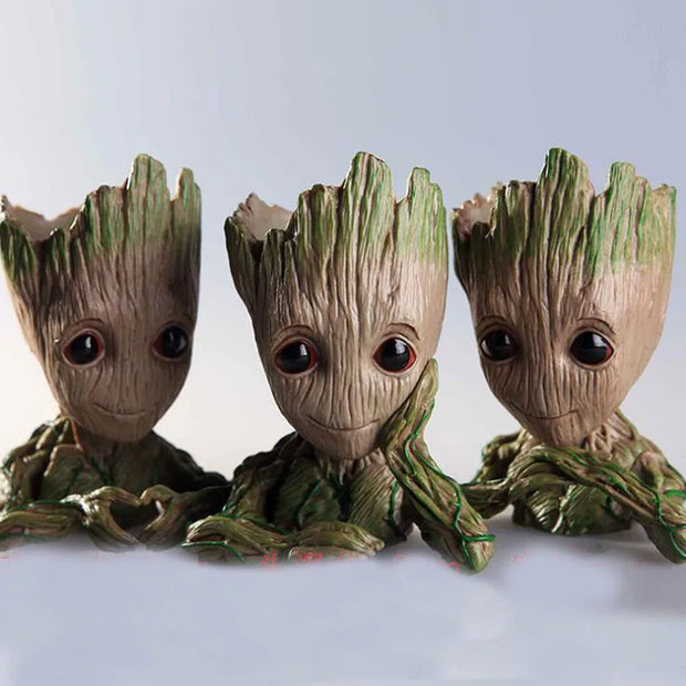 Three Groot figurines from Guardians of the Galaxy on a light gray background