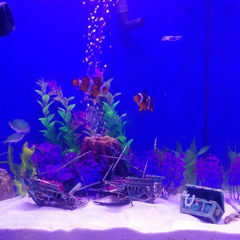 Fish tank with decorative elements and fish under blue lighting