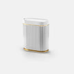 White cylindrical object with gold accents on a white background