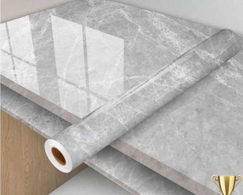 Roll of gray marble-patterned vinyl wrap on a surface