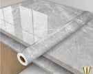 Roll of gray marble-patterned vinyl wrap on a surface