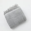 Gray textured throw blanket with fringe on a white background