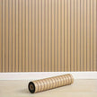 Roll of wooden flooring against a wooden panel wall.
