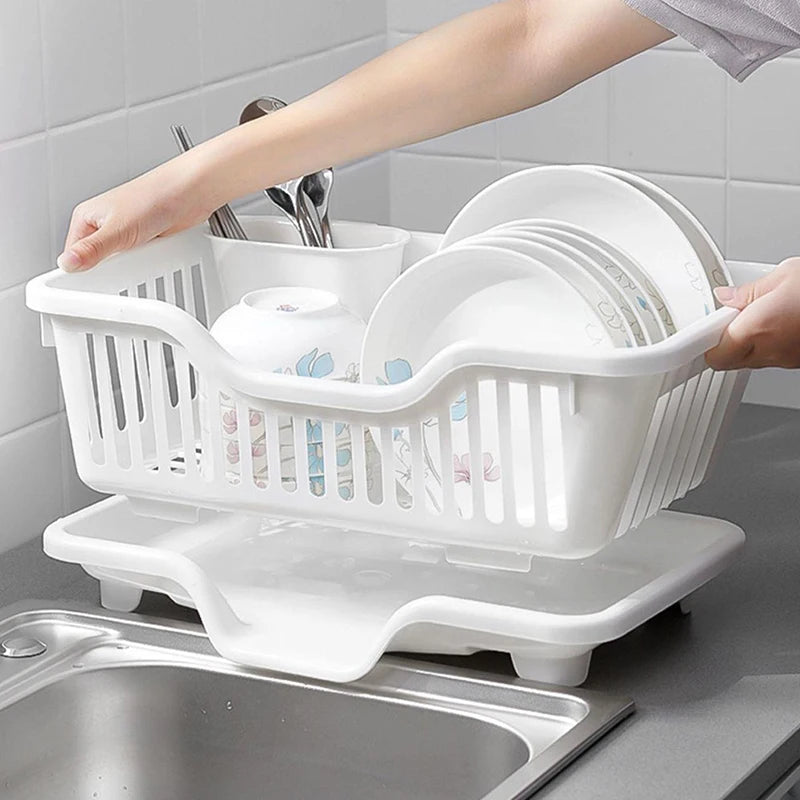 White dish rack with dishes on a kitchen counter next to a sink
