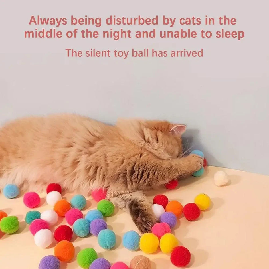 Cat playing with colorful toy balls on a surface, with text above.
