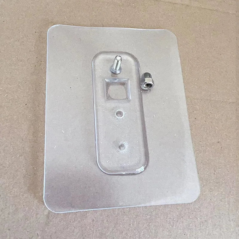 Clear plastic wall plate with mounting hardware on a beige background