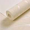 Roll of beige textured wallpaper on a white background