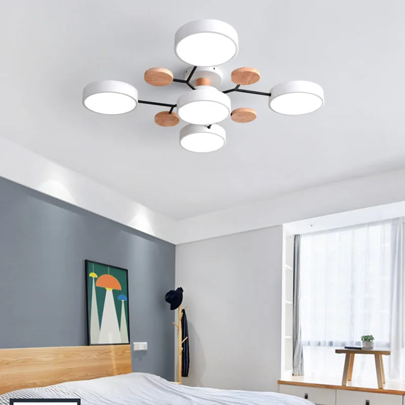 Modern ceiling light fixture in a bedroom with a bed and window in the background.