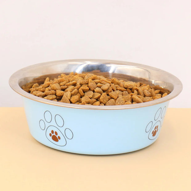 Dog food in a blue and silver bowl with paw prints on a beige surface