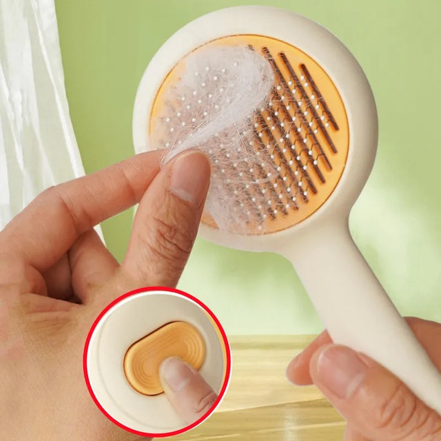 Hand holding a hairbrush with a close-up of the bristle head against a green background