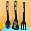 Three black silicone utensils (spoon, spatula, fork) on a blue and orange gradient background.