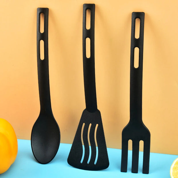 Three black silicone utensils (spoon, spatula, fork) on a blue and orange gradient background.