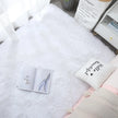 White towel with a small card and pen on a white surface