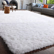 White fluffy rug in a living room setting with a gray sofa and wooden chair.