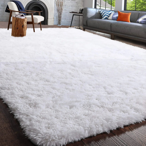 White fluffy rug in a living room setting with a gray sofa and wooden chair.