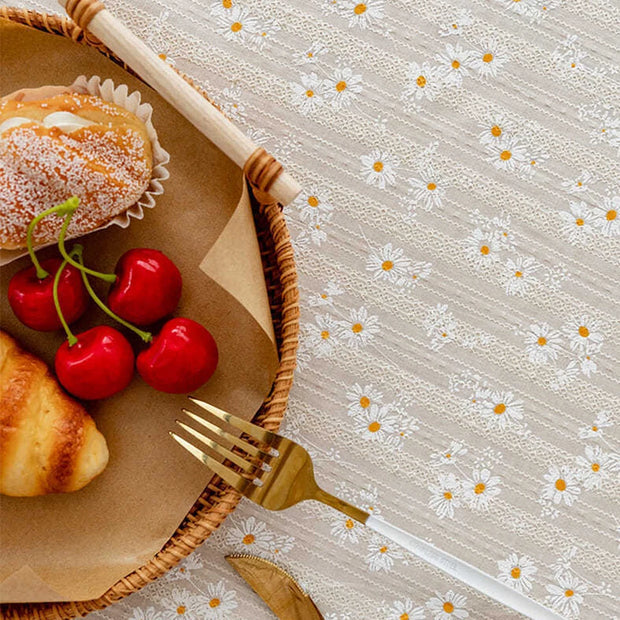 Wicker basket with pastries, cherries, and a gold fork on a floral tablecloth.