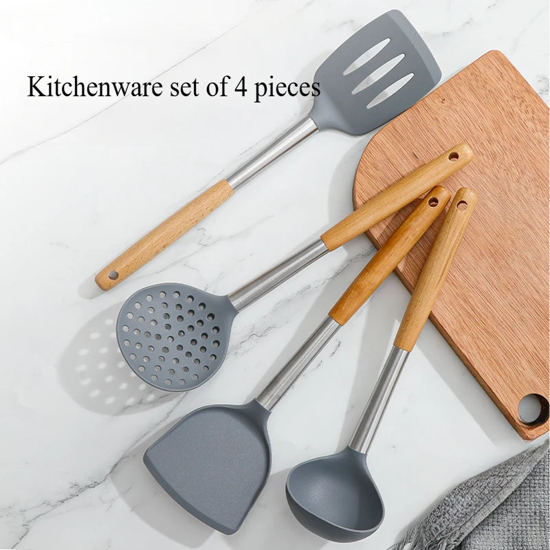 Set of four kitchen utensils with wooden handles on a marble surface
