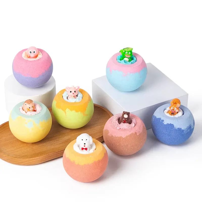 Colorful bath bombs with small animal figurines on a white background