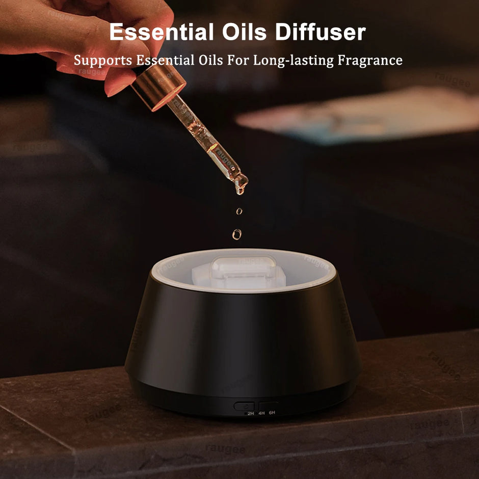 Essential oils being dripped into a black essential oils diffuser on a dark surface.