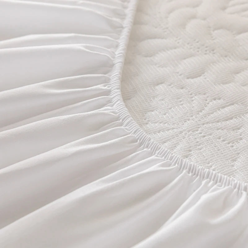 Close-up of a white fitted sheet on a mattress
