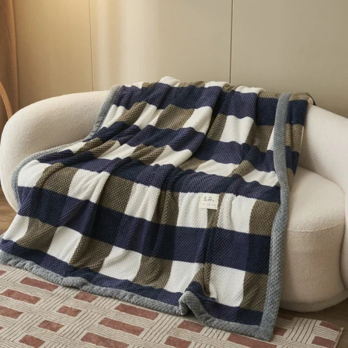 Checkered blanket draped over a white sofa in a living room setting.