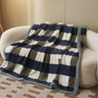 Checkered blanket draped over a white sofa in a living room setting.