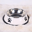 Stainless steel pet bowl with paw prints on a soft white surface