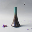 Cylindrical vase with gradient color from green to brown on a gray background