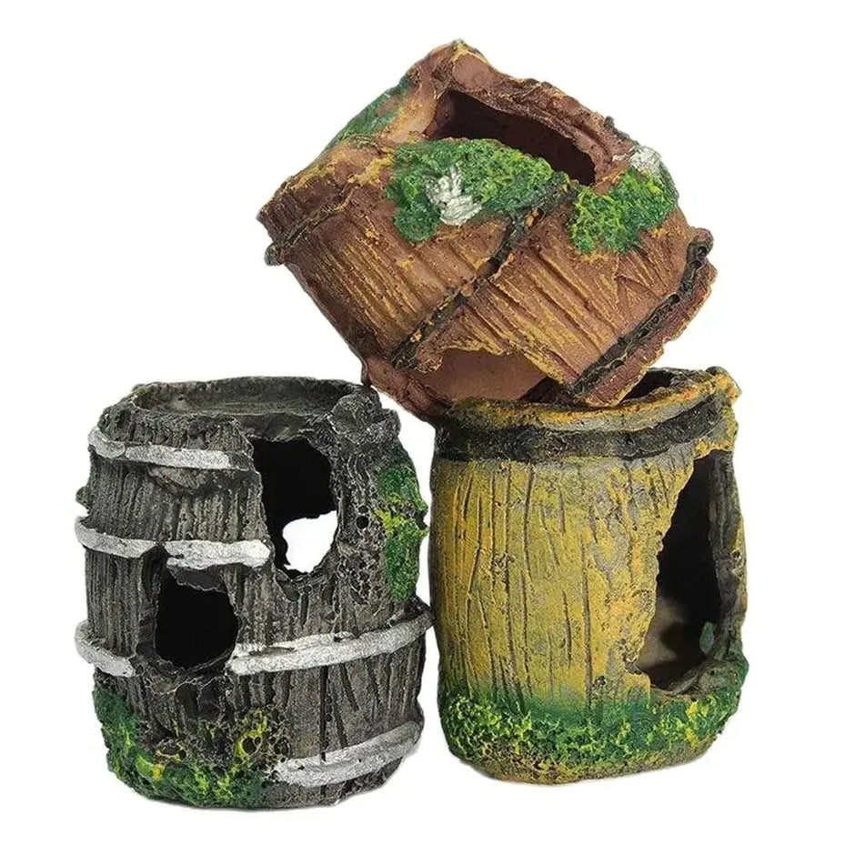 Three decorative aquarium plants resembling wooden barrels with moss on a white background