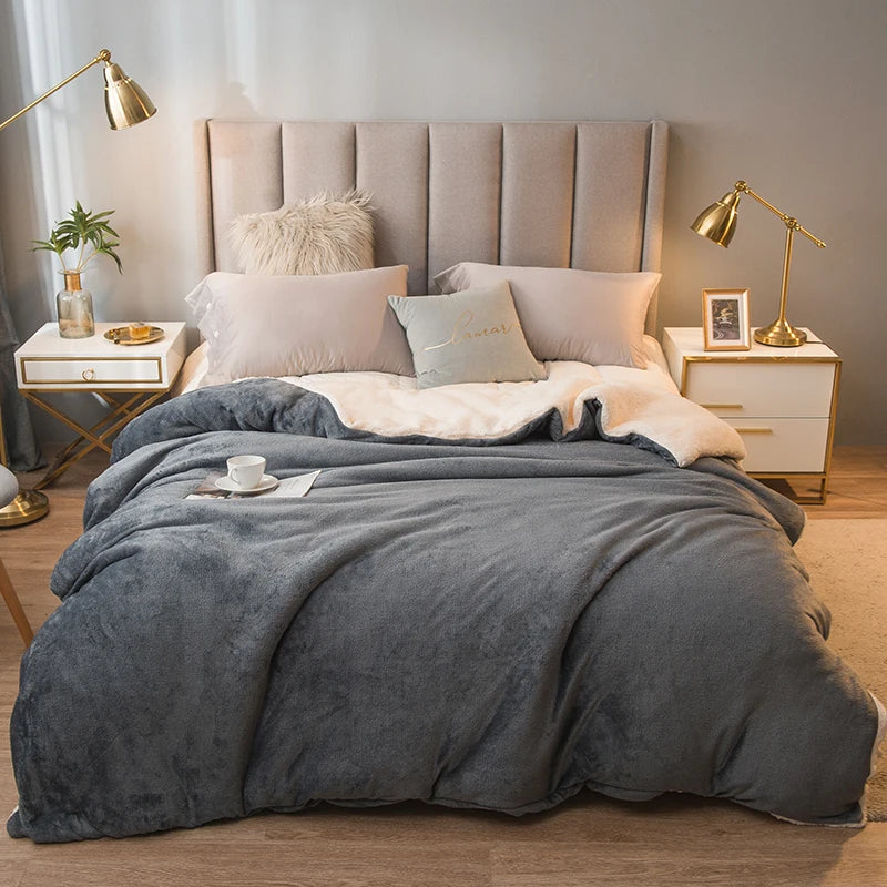 Neatly made bed with gray comforter in a bedroom setting.