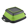 Green and black kitchen tool with perforated top on a white background