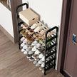 Black shoe rack with various shoes on a wooden floor next to a door.
