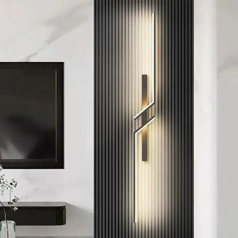 Modern wall sconce in a stylish interior setting with a television and decorative elements.