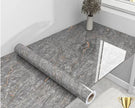 Roll of gray marble-patterned vinyl flooring on a table.