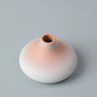 Ceramic vase with gradient color from pink to white on a gray background