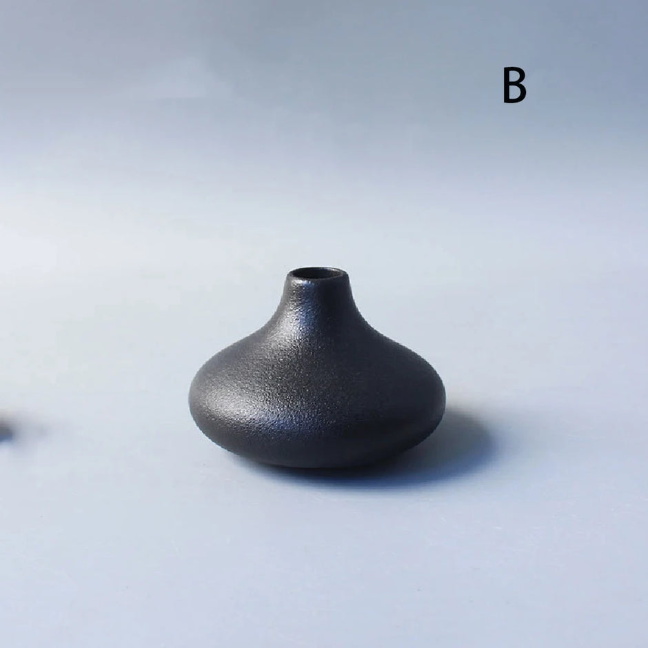 Black ceramic vase on a light gray background