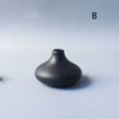 Black ceramic vase on a light gray background
