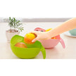 Person placing an apple into a green colander on a kitchen counter.