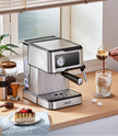 Espresso machine on a kitchen counter with a glass of coffee and a small cake.