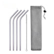 Set of metal straws with cleaning brush and mesh pouch on a white background