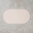 Beige bath mat on a gray concrete floor