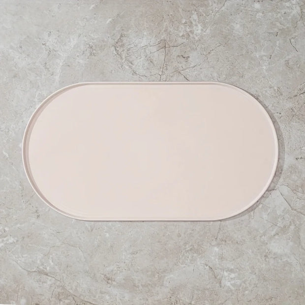 Beige bath mat on a gray concrete floor