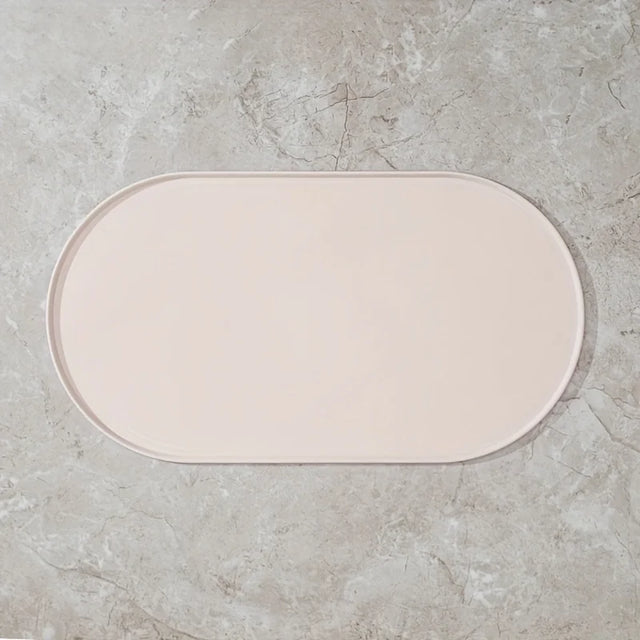 Beige bath mat on a gray concrete floor