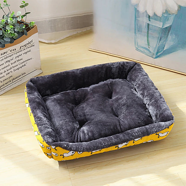 Pet bed with yellow base and gray cushion on a wooden floor
